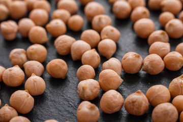 uncooked chickpeas on a dark stone background