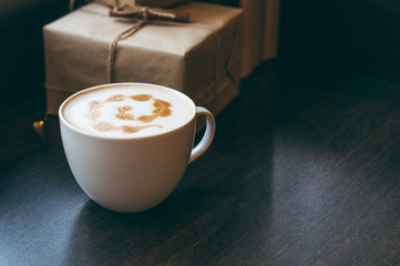 Cup of cappuccino with beautiful latte art on wooden table. Flat lay style.