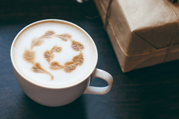 Cup of cappuccino with beautiful latte art on wooden table. Flat lay style.