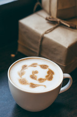 cappuccino latte coffee art in cup on old wooden loft style desk , soft focus with dark tone