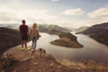 Hiking couple looking at the view holding hands. Location: the meanders of Arda river, Bulgaria