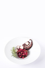 Salad from beetroot and octopus. Vinegret is a traditional Russian salad made from beets and vegetables. The background is white.  Copy space. Vertical shot.