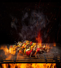 Chicken skewers on the grill with flames