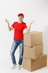 Full length portrait of delivery woman in red cap, t-shirt isolated on white background. Female courier or dealer standing near empty cardboard boxes. Receiving package. Copy space for advertisement.