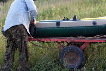 Obraz premium man shakes air pump rubber boat