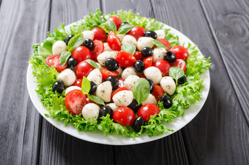 Salad with basil , tomatoes , olives and mozzarella
