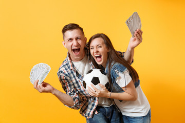 Young win couple, woman man, football fans holding bundle of dollars, cash money, soccer ball,...