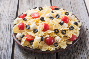 Pasta salad with mozzarella , olives and tomatoes