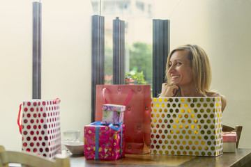 Happy  fashion woman with shopping bags sitting