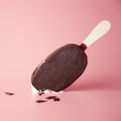 chocolate ice cream bite and crumbled on a pink background. summ