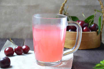 Kissel with cherries in a glass on an old wooden background, traditional russia or poland drink, berry jelly, mousse, summer pink drink,