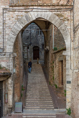 Fototapeta na wymiar Street with arch and stairs doorway in Italy