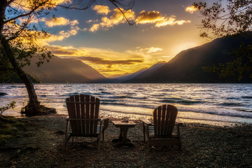 Sunset over Lake Crescent with two wooden chairs on the shore, Olympic National Park, Washington...
