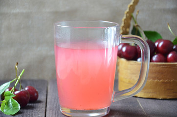 Kissel with cherries in a glass on an old wooden background, traditional russia or poland drink, berry jelly, mousse, summer pink drink,