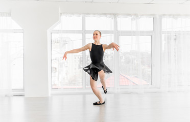 Fototapeta na wymiar Young ballerina practising ballet moves