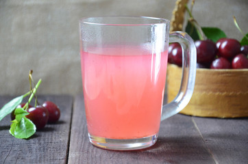 Kissel with cherries in a glass on an old wooden background, traditional russia or poland drink, berry jelly, mousse, summer pink drink,