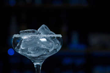 Ice-filled cocktail glass with sugar crockery