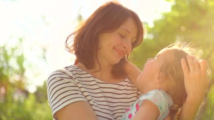 Beautiful mother and her little daughter in summer park. Slow motion. 4K UHD video 3840x2160