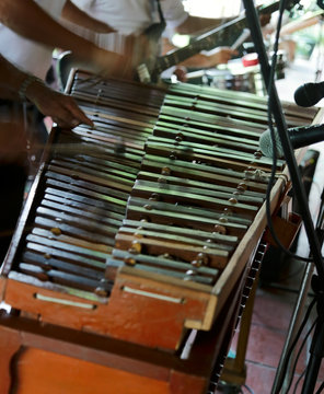 A traditional wooden marimba being played by musicians.