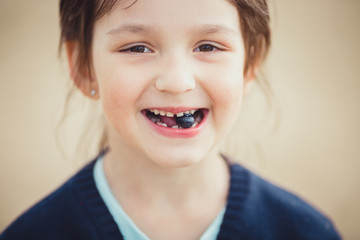 The girl eating blueberries from a glass bowl 