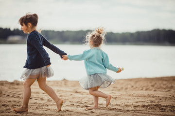 Two sisters playing on the shore of the lake - 211847705