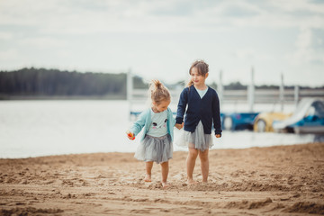 Two sisters playing on the shore of the lake