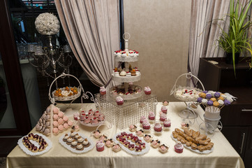 Candy bar/Wedding candy bar display featuring all sorts of delicious cookies and sweets arranged in special trays and supports.