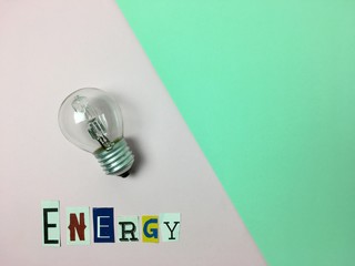 Bombilla con la palabra “energy” sobre fondo rosa y verde.