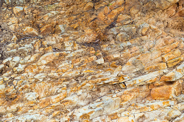 Stone texture. Rock formation with cracks and protrusions. Mountain of castle San Juan. Spanish beach resort Blanes in summertime, Costa Brava, Catalonia, Spain