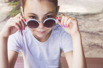 Happy little girl with sunglasses sitting