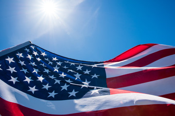 Close up United States of America flag on the blue sky background. USA Independence day, 4 July. © Siam