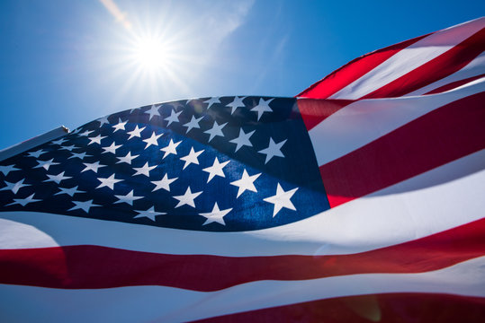 Close up United States of America flag on the blue sky background. USA Independence day, 4 July.