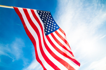 Close up United States of America flag on the blue sky background. USA Independence day, 4 July.
