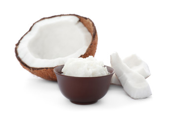 Ripe coconut and bowl with oil on white background. Healthy cooking