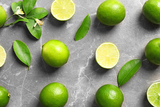 Flat lay composition with fresh ripe limes on gray background, top view