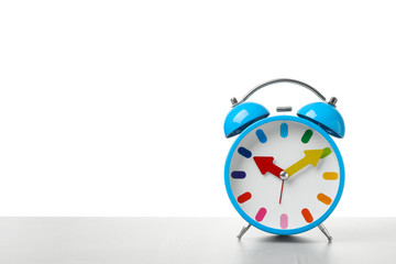Alarm clock on table against white background. Time concept