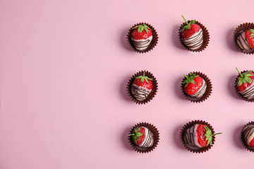 Flat lay composition with chocolate covered strawberries on color background