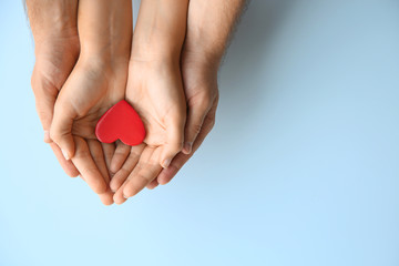Young couple with red heart on white background, top view