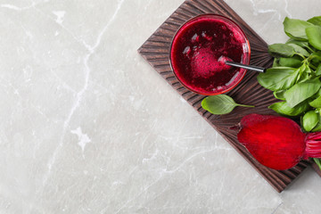 Glass of fresh beet juice, basil and vegetable on table, top view