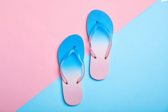 Stylish beach flip-flops on color background, top view