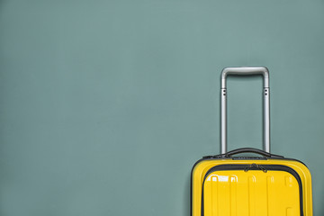 Packed bright yellow suitcase on color background