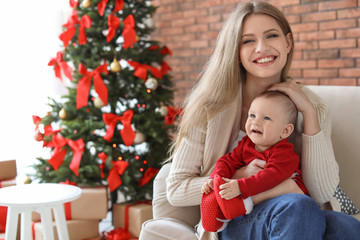 Fototapeta na wymiar Young woman with baby celebrating Christmas at home