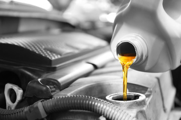 Pouring oil into car engine, closeup
