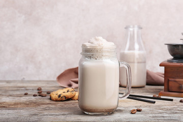 Mason jar with delicious milk shake on wooden table