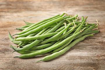 Fresh green French beans on wooden table