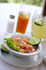 A close up of  a shrimp cocktail dish in a natural light environment with real shrimp and lemon.