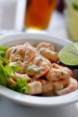A close up of  a shrimp cocktail dish in a natural light environment with real shrimp and lemon.