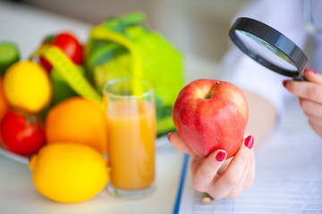 Diet. Doctor Nutritionist hold red apple in her office. Concept of natural food and healthy lifestyle. Fitness and healthy food diet concept. Balanced diet with vegetables.