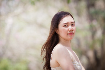 Asian women aged between 25-30 years old posting on natural blurred background close up.