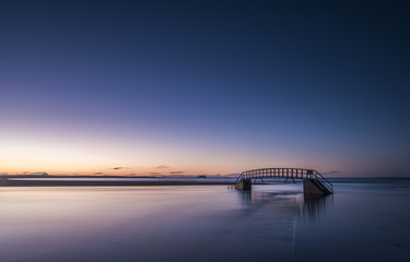 Known as The Bridge To Nowhere, bridge over Biel Water where it flows into Belhaven Bay and the North Sea at Dunbar at sunset, East Lothian, Scotland